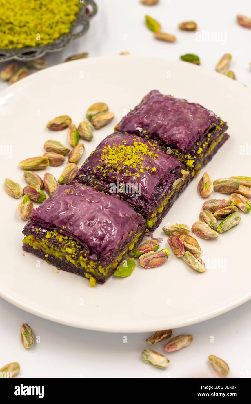 Pistacchio baklava viola su sfondo bianco. Baklava appositamente preparato per i diabetici. Specialità della cucina mediterranea tradizionale. Primo piano Foto Stock