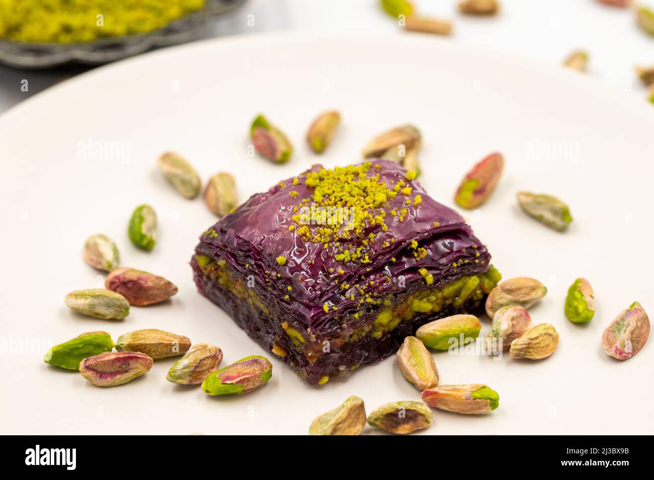 Pistacchio baklava viola su sfondo bianco. Baklava appositamente preparato per i diabetici. Specialità della cucina mediterranea tradizionale. Primo piano Foto Stock