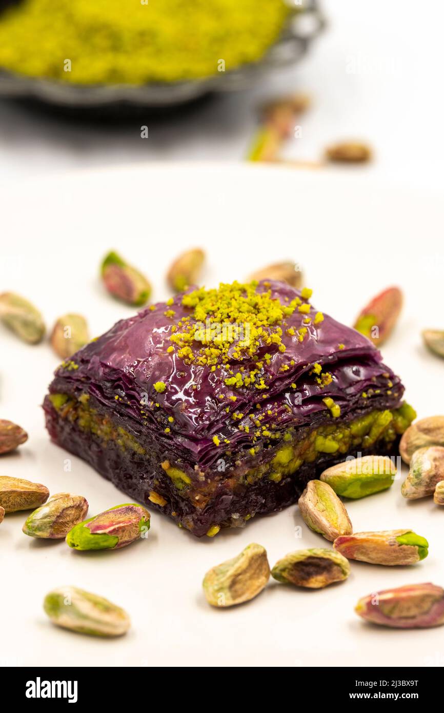Pistacchio baklava viola su sfondo bianco. Baklava appositamente preparato per i diabetici. Specialità della cucina mediterranea tradizionale. Primo piano Foto Stock