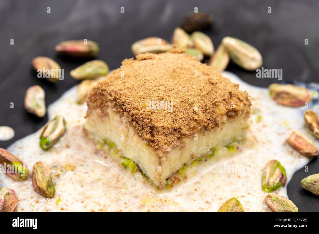 Baklava freddo su sfondo bianco. Il baklava freddo preparato con latte e pistacchio è molto popolare. Specialità della cucina mediterranea tradizionale. Chiuso Foto Stock