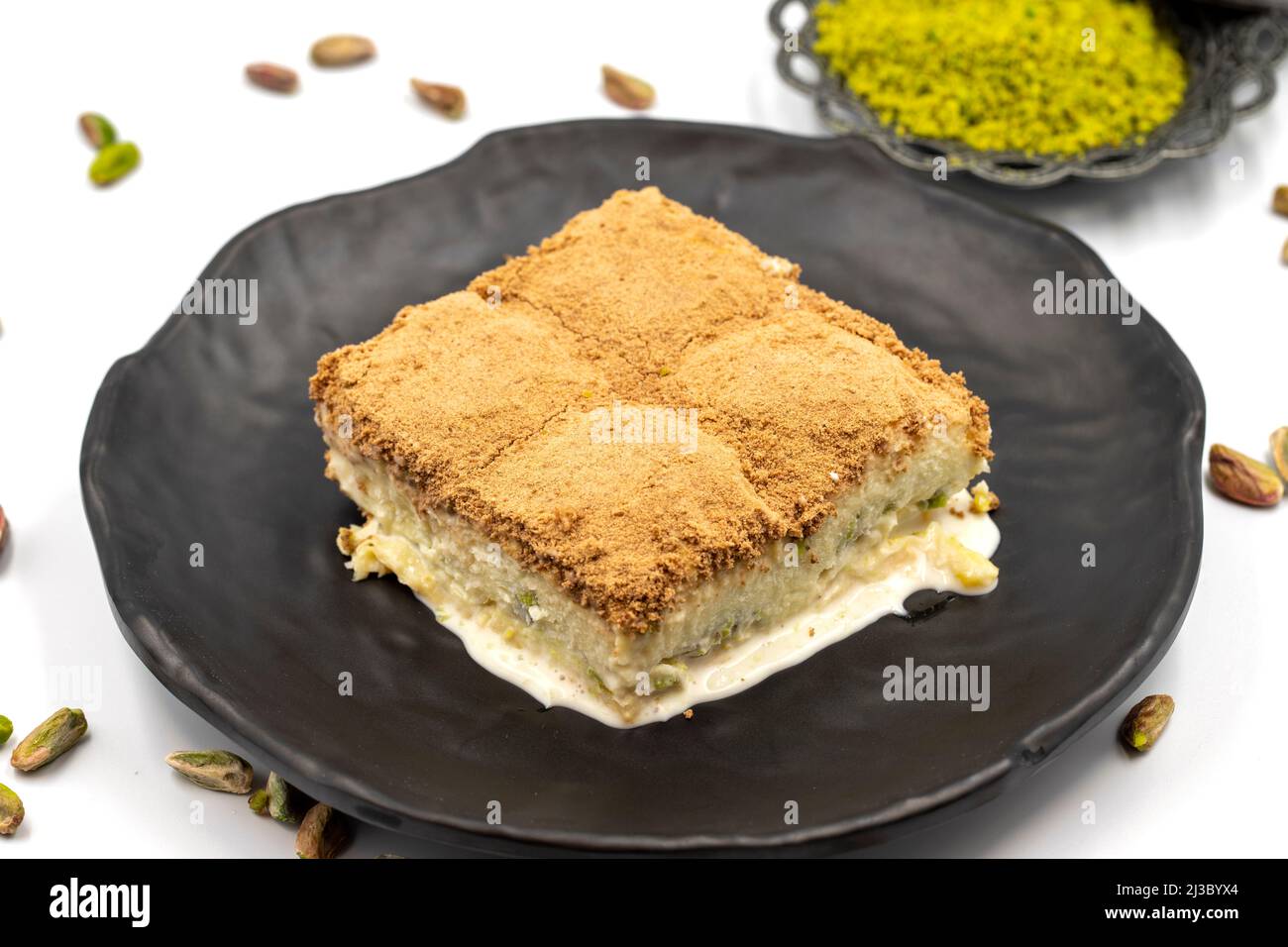Baklava freddo su sfondo bianco. Il baklava freddo preparato con latte e pistacchio è molto popolare. Specialità della cucina mediterranea tradizionale. Chiuso Foto Stock