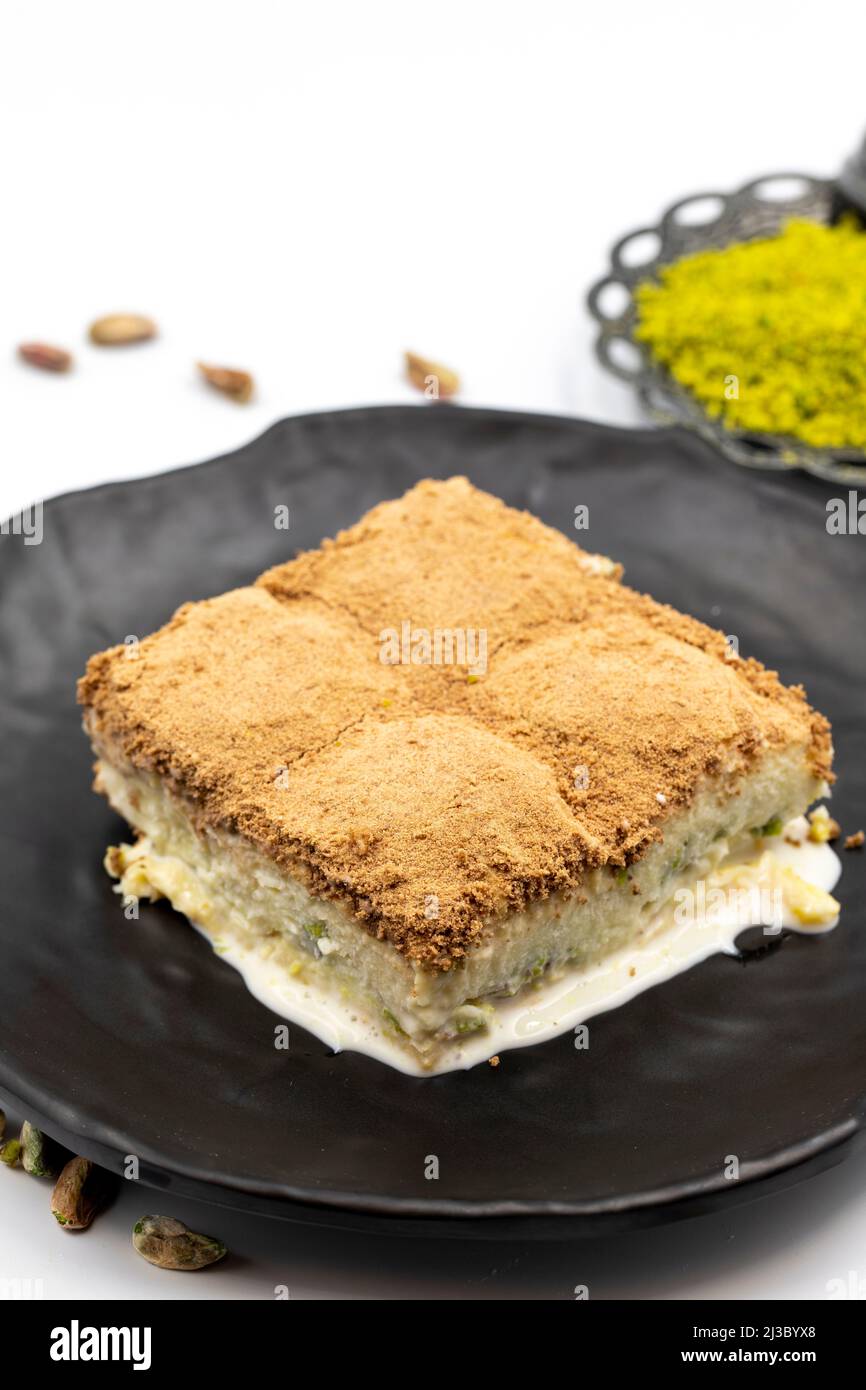 Baklava freddo su sfondo bianco. Il baklava freddo preparato con latte e pistacchio è molto popolare. Specialità della cucina mediterranea tradizionale. Chiuso Foto Stock