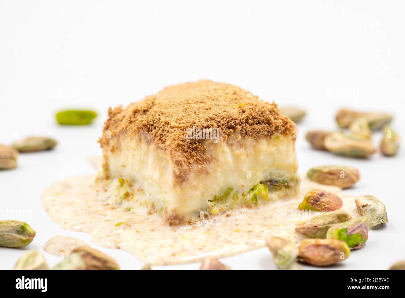 Baklava freddo su sfondo bianco. Il baklava freddo preparato con latte e pistacchio è molto popolare. Specialità della cucina mediterranea tradizionale. Chiuso Foto Stock