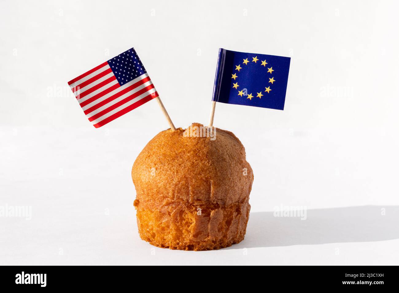 Cupcake fatto in casa con bandiere USA ed UE su sfondo bianco. Il concetto di cooperazione tra paesi. Il concetto di relazioni commerciali tra COUNT Foto Stock