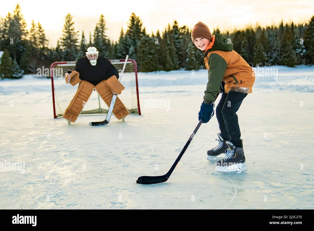 ritratto di hockey felice con suo padre su un lago Foto Stock