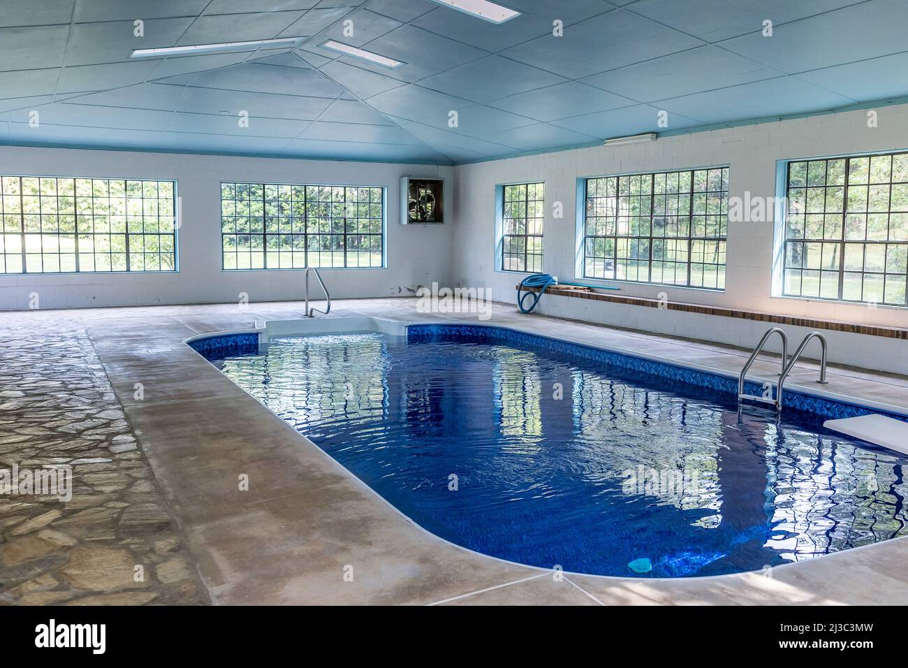 Grande piscina interna con molta luce naturale dalle grandi finestre in un atrio Foto Stock