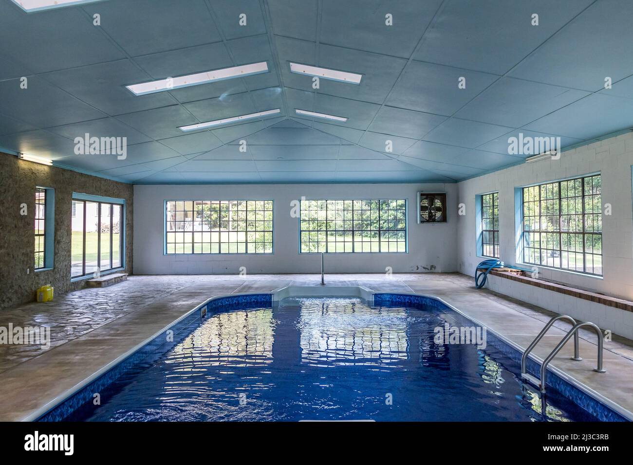 Grande piscina interna con molta luce naturale dalle grandi finestre in un atrio Foto Stock