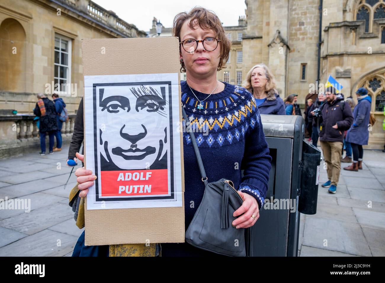 I manifestanti fuori dall'Abbazia di Bath detengono cartelli anti-guerra mentre prendono parte a una manifestazione contro l'invasione russa dell'Ucraina Foto Stock