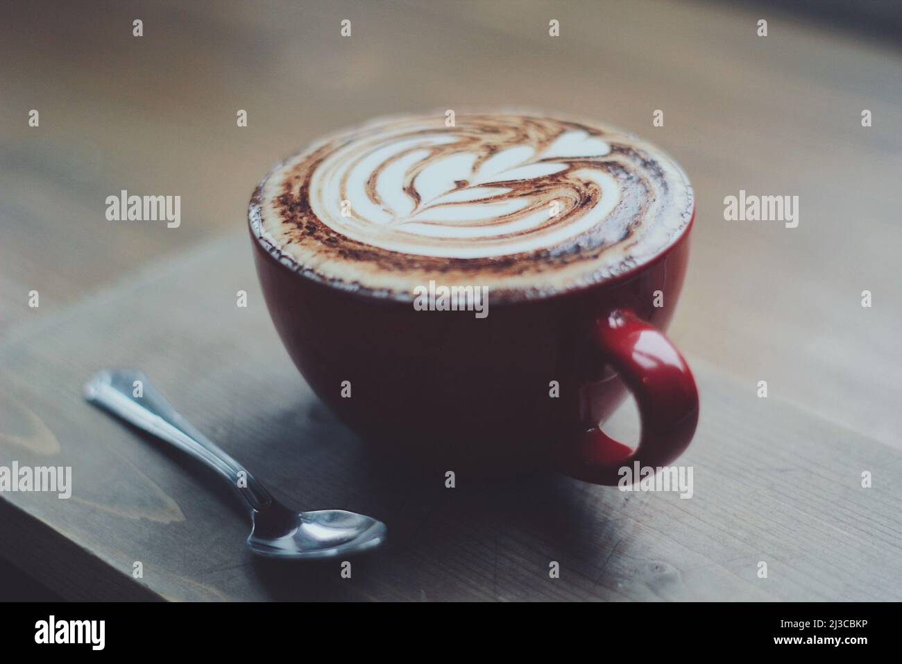 Cappuccino in una tazza rossa Foto Stock