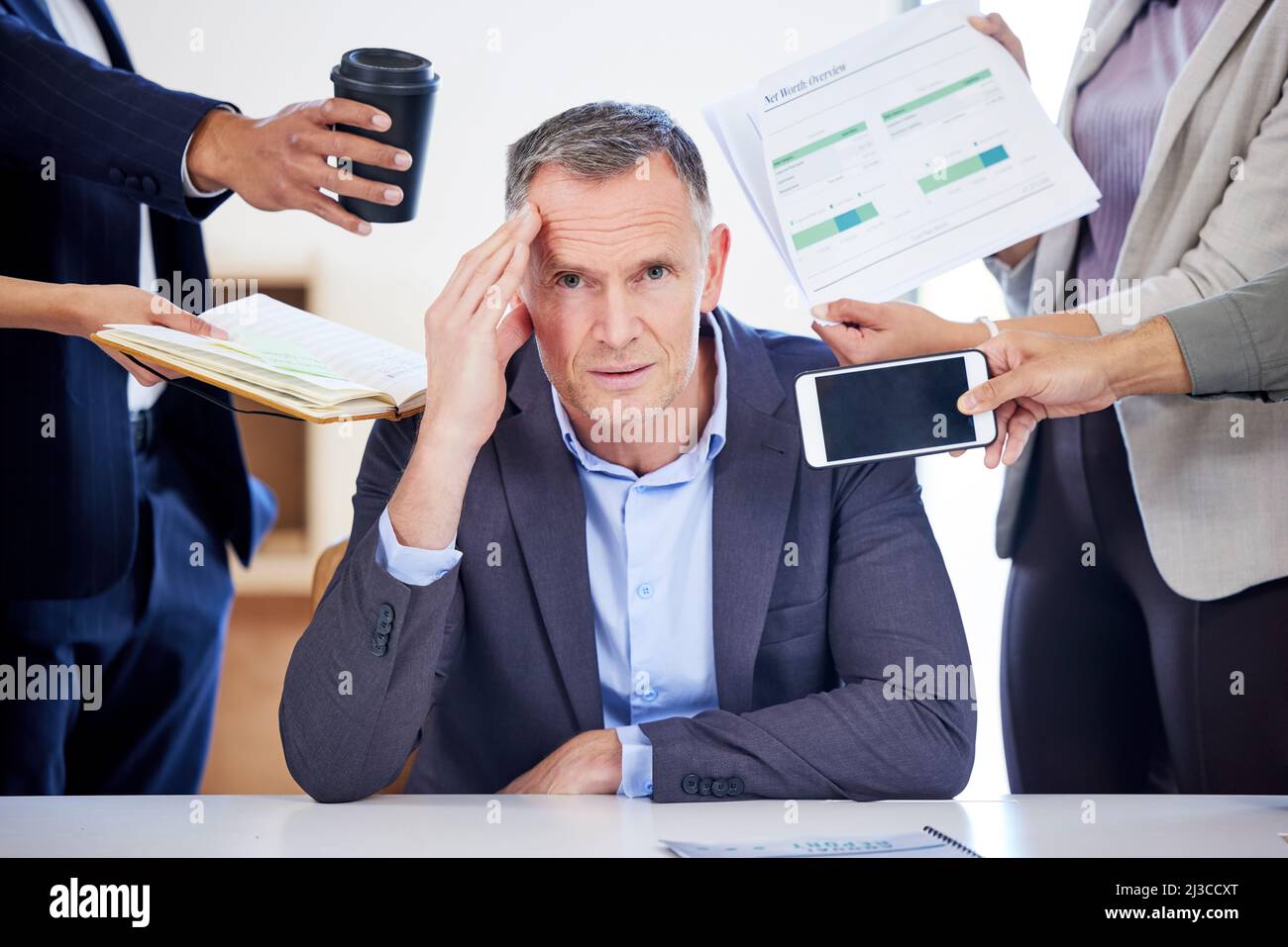 I miei giorni sono pieni di troppe scadenze. Ritratto di un uomo d'affari maturo che osserva sottolineato fuori in un ambiente d'ufficio esigente. Foto Stock
