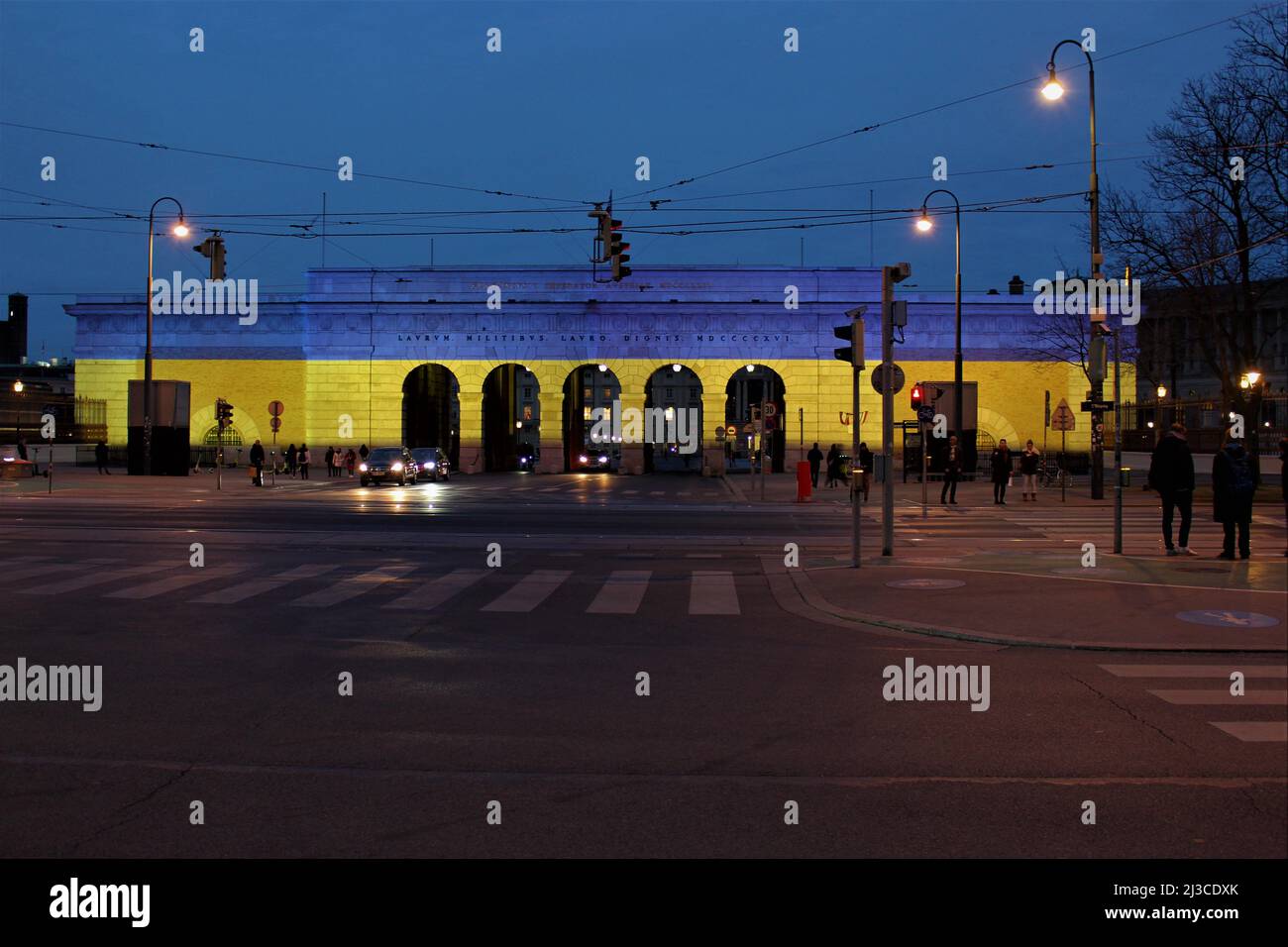 Solidarietà austriaca con l'Ucraina. Hofburg cancello illuminato in colori ucraini bandiera. Foto Stock