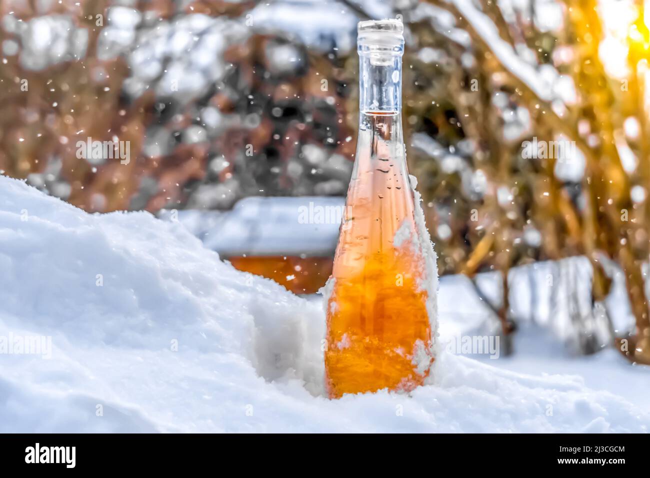 una bottiglia di vino nella neve fredda durante una nevicata Foto Stock