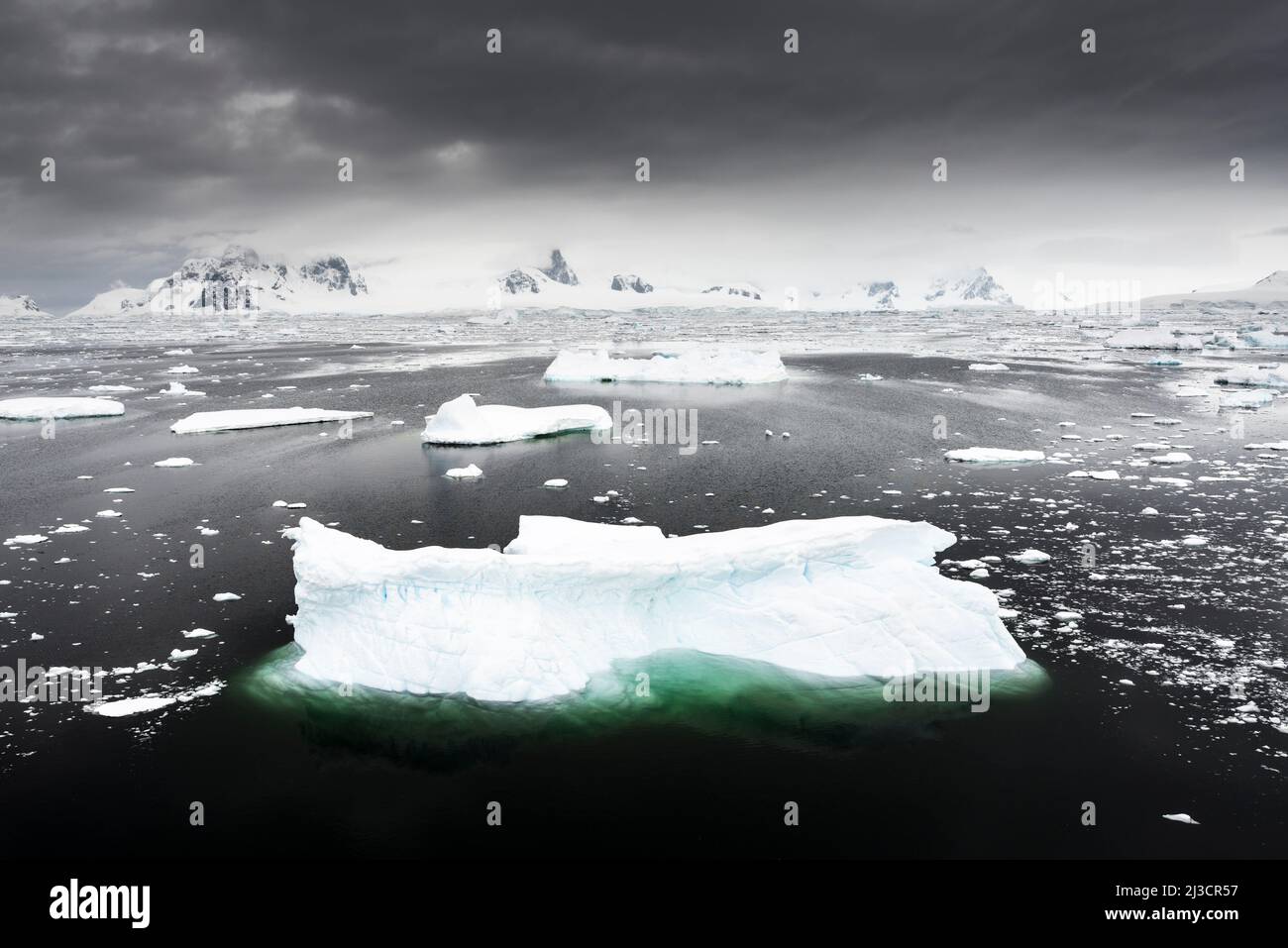 Paesaggio che guarda ad est dall'Isola di Adelaide, con iceberg, ghiaccio marino e montagne. Antartide Foto Stock