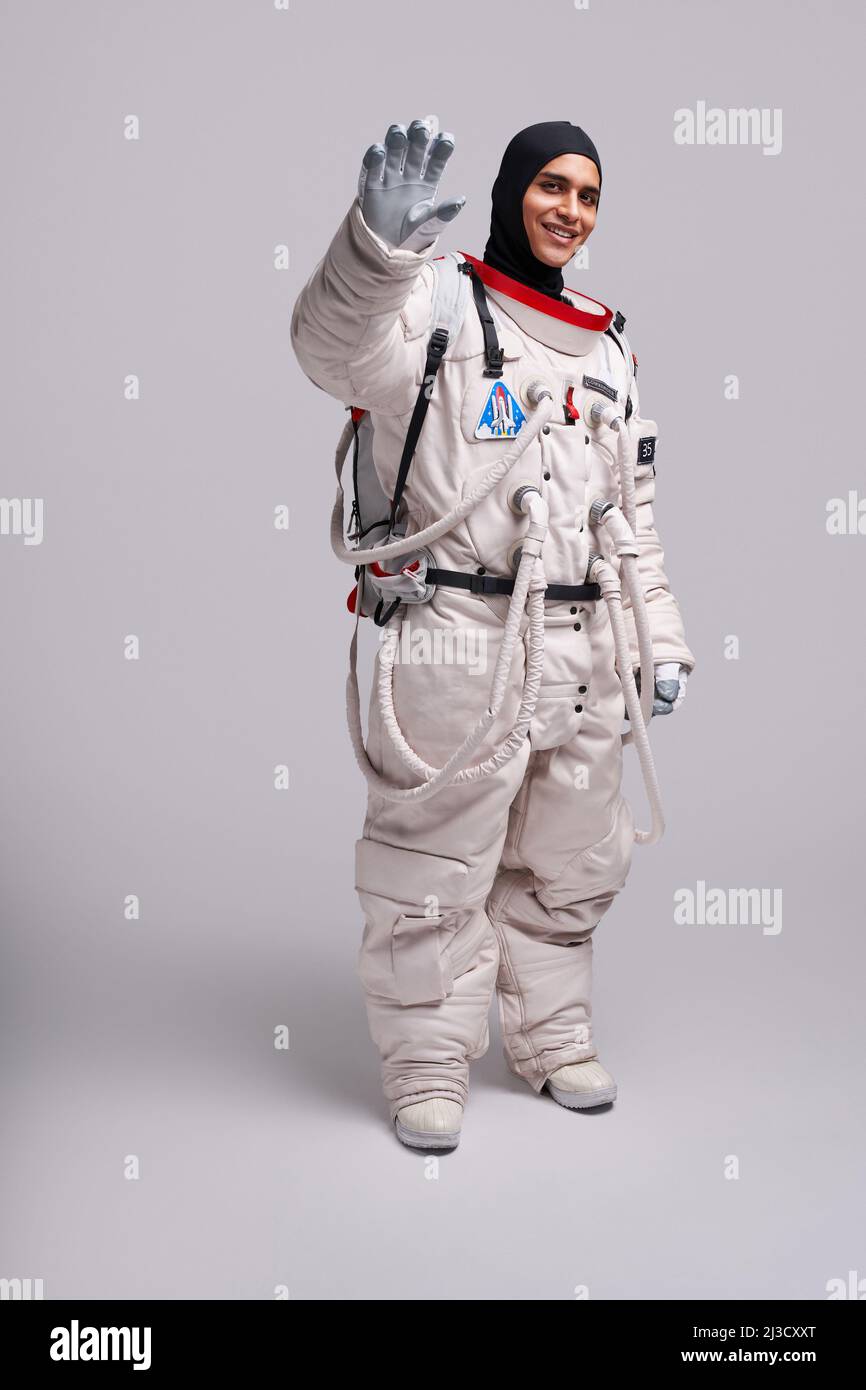 Corpo pieno di un astronave colombiano che agita Arrivederci prima di volare nello spazio per esplorare l'universo in studio su sfondo bianco Foto Stock Corpo pieno di un astronave colombiano che agita Arrivederci prima di volare nello spazio per esplorare l'universo in studio su sfondo bianco Foto Stock