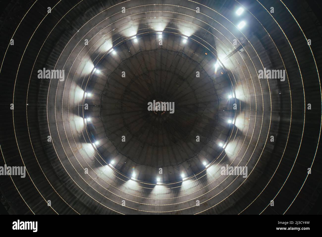 Da sotto la luce del sole che brilla attraverso un foro rotondo nel soffitto dell'impianto industriale durante il giorno Foto Stock