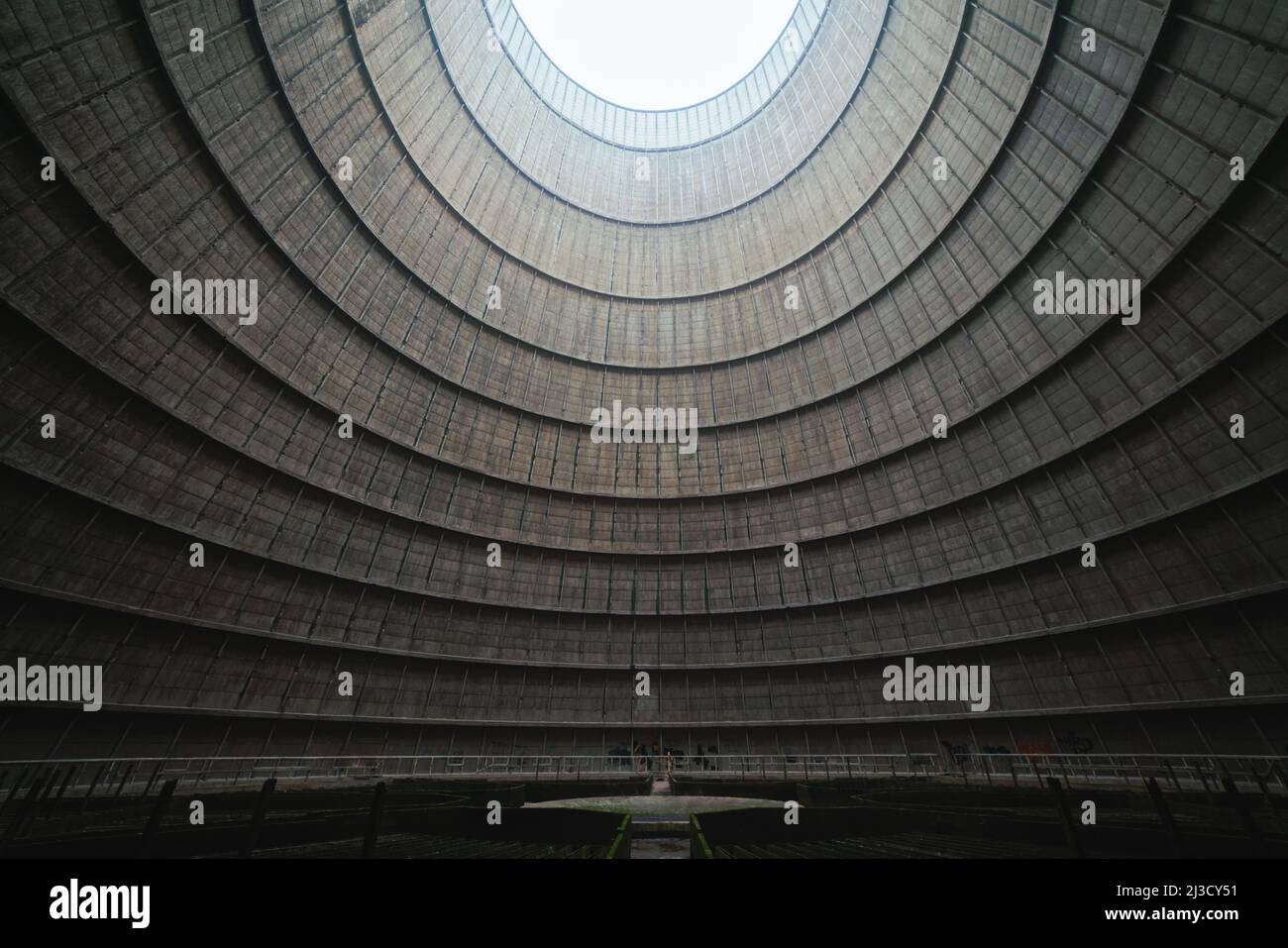Da sotto la luce del sole che brilla attraverso un foro rotondo nel soffitto dell'impianto industriale durante il giorno Foto Stock