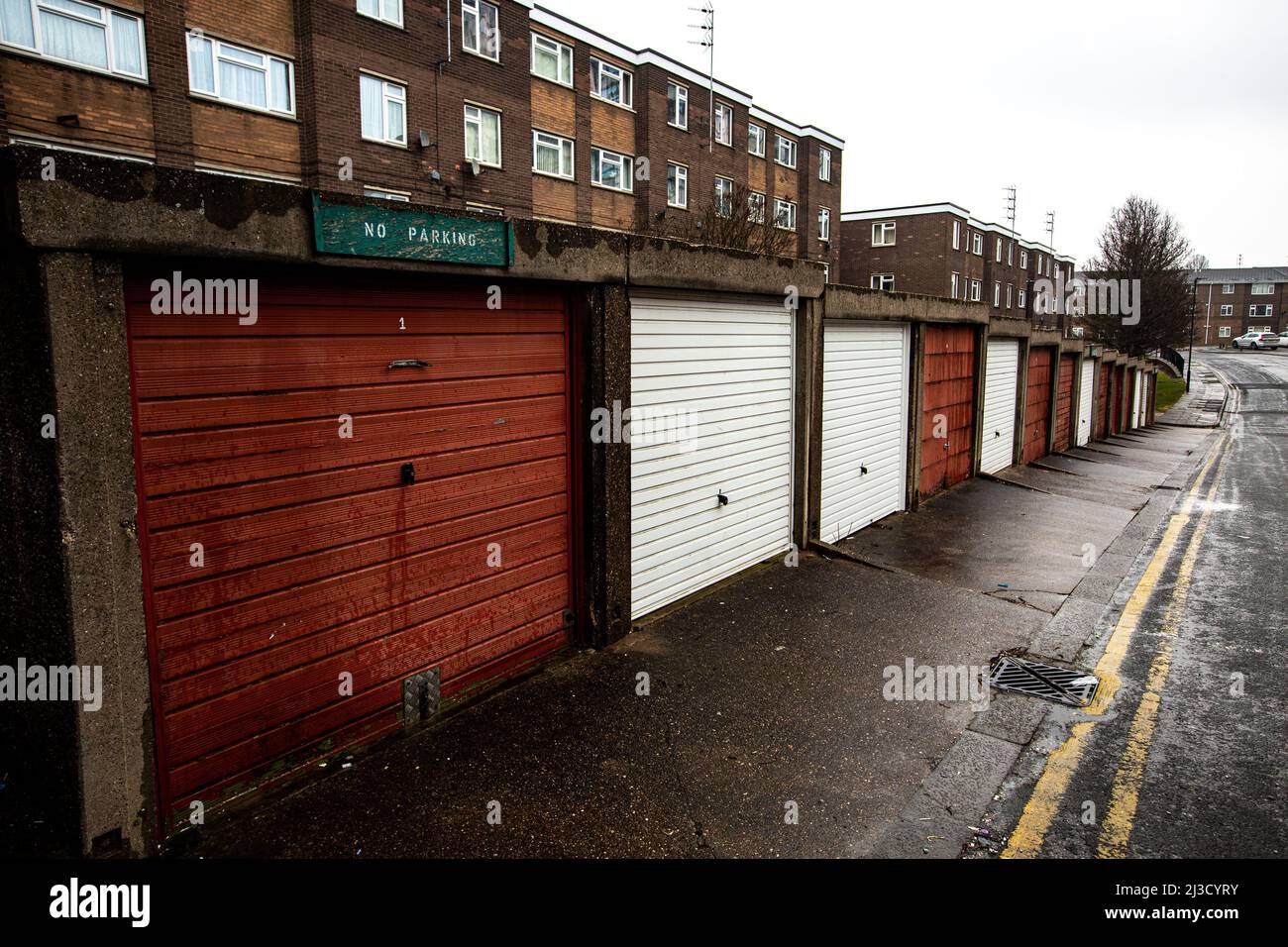 Una tenuta del consiglio con l'alloggiamento sociale in blocchi di torre e file di garage disutilizzati nel nord dell'Inghilterra durante il livellamento del governo britannico Foto Stock