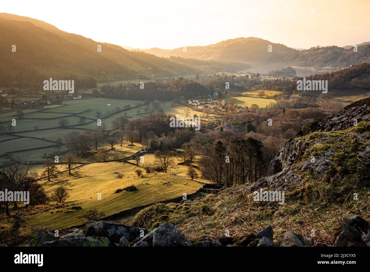 Una vista aerea del paesaggio di prima mattina del villaggio di Grasmere nel Lake District Nation Park con alberi di luce del sole e spazio copia Foto Stock