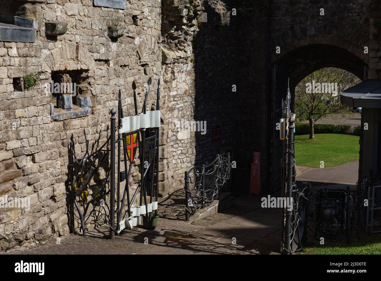 All'interno della Gatehouse, il Castello di Chepstow, che mostra nuove porte in ferro decorate con spade e creste medievali. Foto Stock