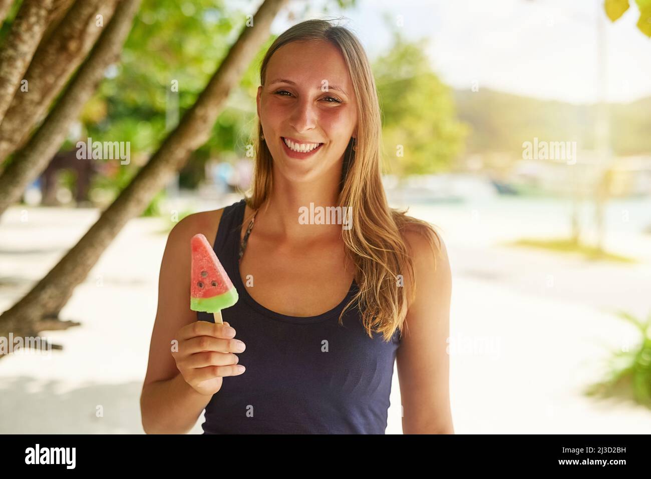 Il mio spuntino estivo preferito. Ritratto di una giovane donna attraente godendo di un pop cicle sulla spiaggia. Foto Stock