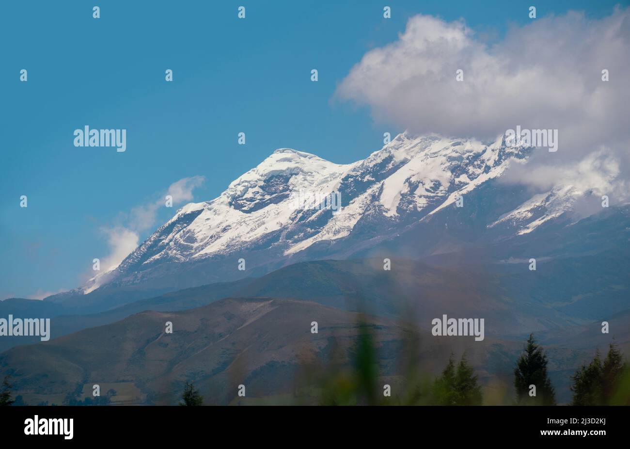 Vista del vulcano Cayambe dalla città di Olmedo nella provincia di Cayambe durante una mattinata di sole e cielo blu - Ecuador Foto Stock