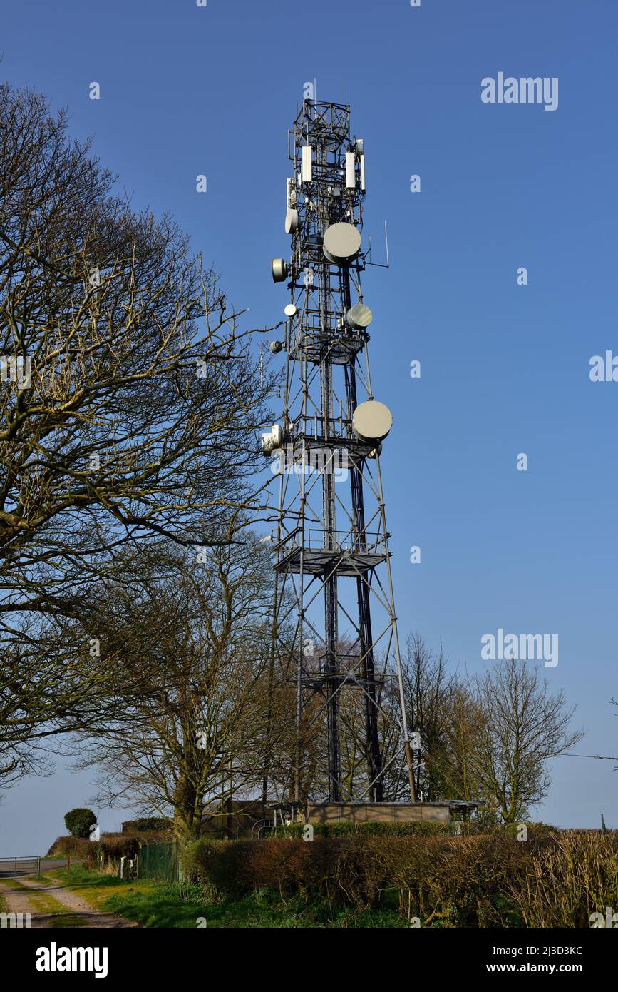 Torre di comunicazione con antenne per telefoni cellulari e piastre a microonde Foto Stock