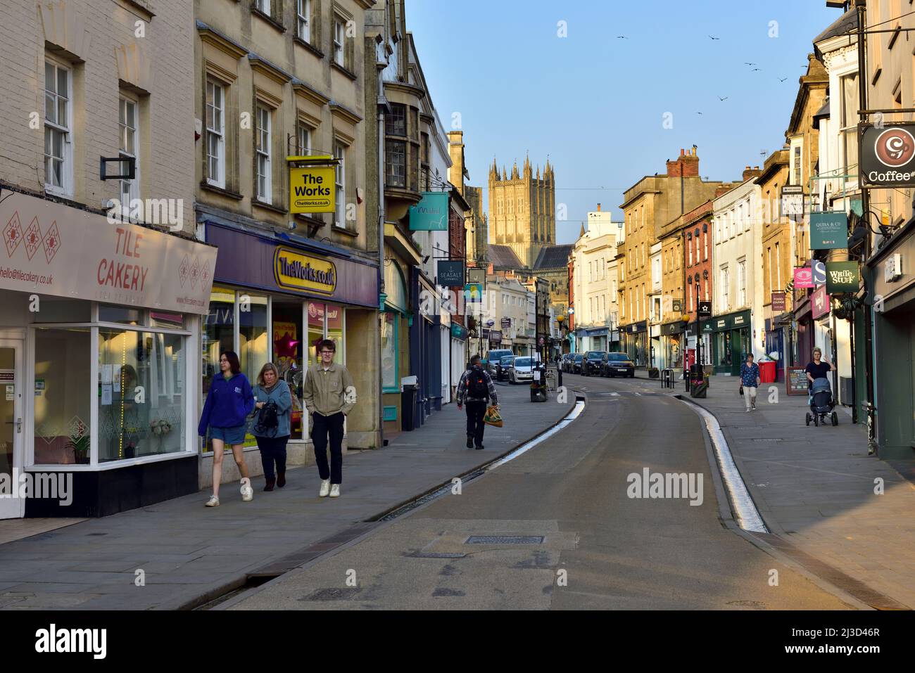 Pozzi, Somerset edifici di alta strada, negozi, Regno Unito con la cattedrale in background Foto Stock