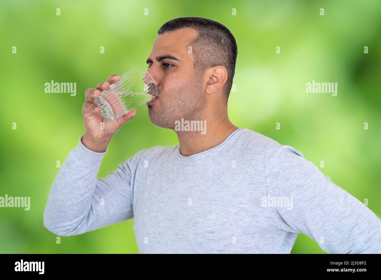 Primo piano foto di uomo sportivo bruno con pelle che beve acqua. Concetto di consumo giornaliero di acqua o di presa per la salute Foto Stock