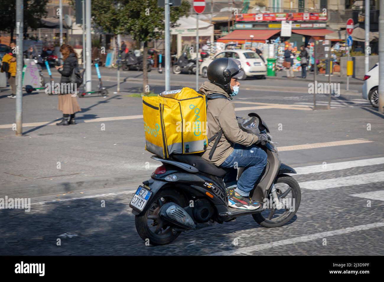 Napoli, Italia - 25 marzo 2022: Glovo, ragazzo consegna il cibo a casa  portandolo con lo scooter nello speciale zaino termico Foto stock - Alamy