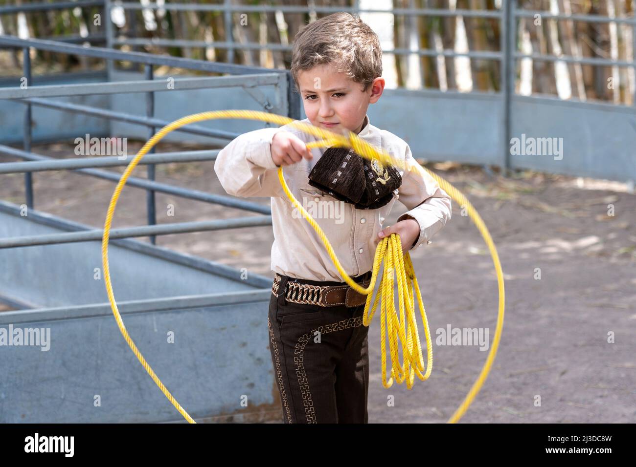 Un giovane ragazzo messicano che indossa un abito charro, mostra le sue abilità di roping al Campionato di Stato Charreria a Rancho El Pitayo 3 aprile 2022 a Tlacote el Bajo, Queretaro, Messico. Le Charrerias tradizionali sono competizioni equestri dagli haciendas del vecchio Messico ed è l'origine del rodeo americano. Foto Stock