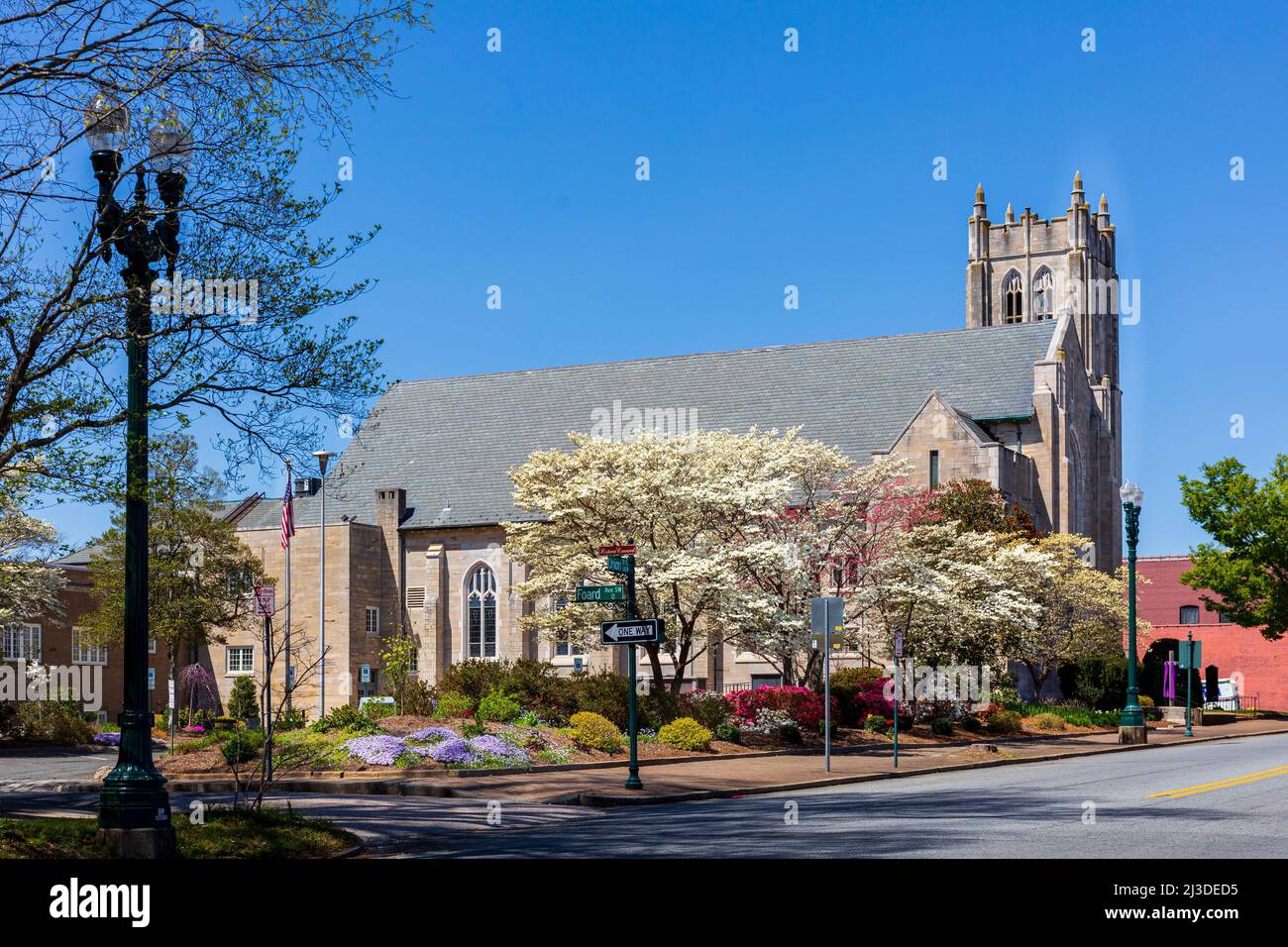 CONCORD, NC, USA-3 APRILE 2022: St. James Lutheran Church, con campanile, all'angolo tra Union e Corban., con snubbery fiorito primaverile e alberi in Foto Stock