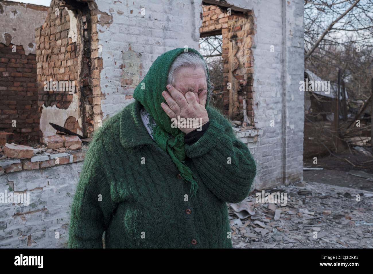 Liubov Khomenko reagisce mentre attraversa la sua casa distrutta, in mezzo all'invasione russa dell'Ucraina nel villaggio di Andriivka, nella regione di Kyiv, Ucraina, il 7 aprile 2022. REUTERS/Marko Djurica Foto Stock