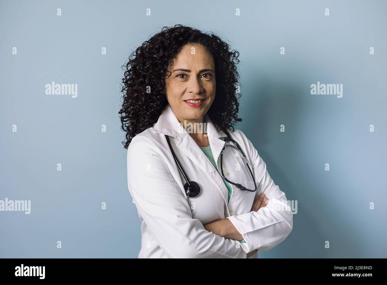 ispanico medico donna ritratto con copia spazio su sfondo blu ridendo in Messico America Latina Foto Stock