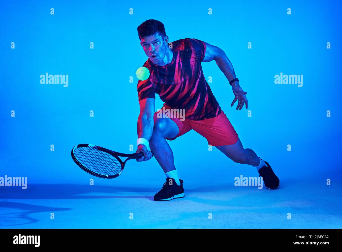 Lasciate che il racket faccia la conversazione. Scatto con filtro blu di un giocatore di tennis in studio. Foto Stock