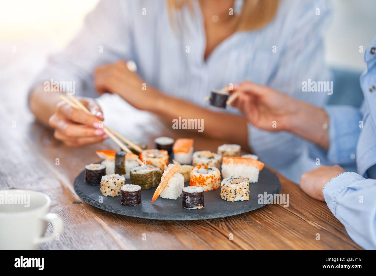 Belle due ragazze adulte in casa che mangiano sushi Foto stock - Alamy