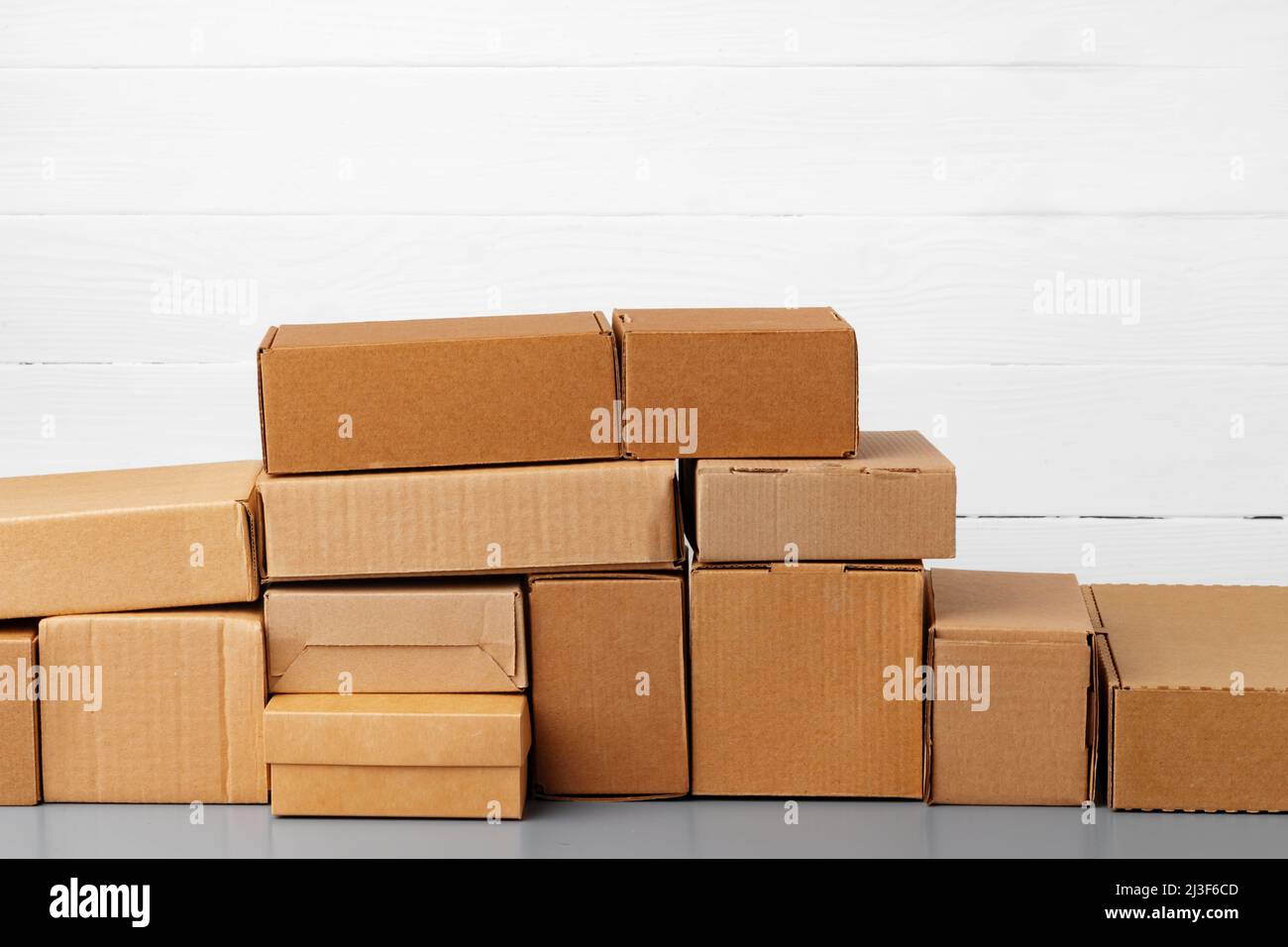 Gruppo di scatole di cartone contro il muro di legno bianco Foto stock -  Alamy