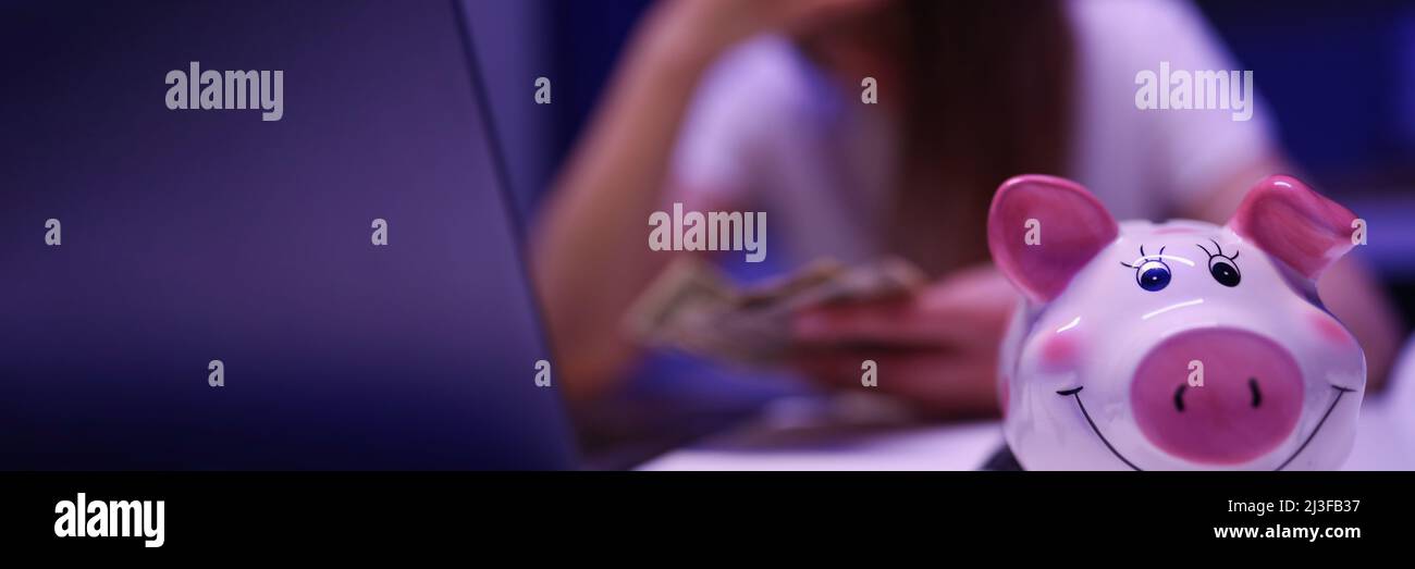 Donna cercare di salvare in su in moneybox Foto Stock