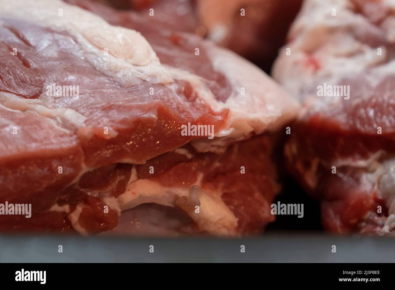 Carne fresca e cruda. Intero pezzo di bistecche in fila pronto per cucinare. Centro di messa a fuoco selettiva Foto Stock