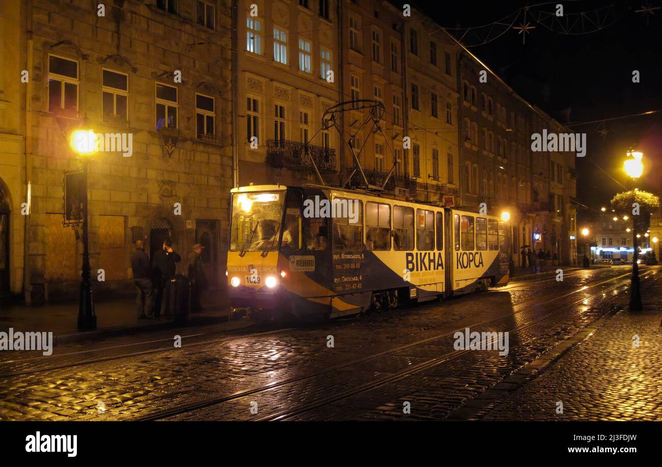 Servizio tram notturno sotto la pioggia, Piazza Rynok, centro città, Lviv, Ucraina Foto Stock