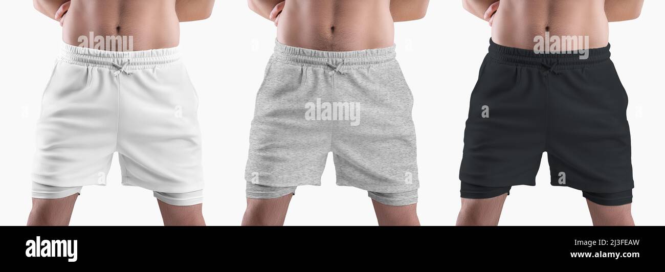 Mockup di pantaloncini bianchi, neri, in erica sciolti con linea di compressione sul corpo atletico maschio, isolato sullo sfondo. Imposta. Modello di abbigliamento con sottobosco Foto Stock