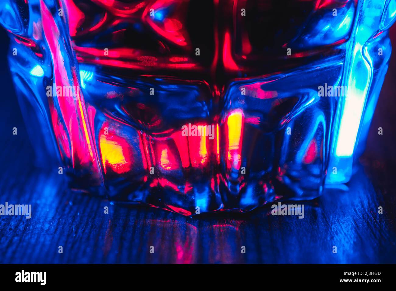 Primo piano tintura di colore rosso in vetro cristallo con illuminazione al neon Foto Stock