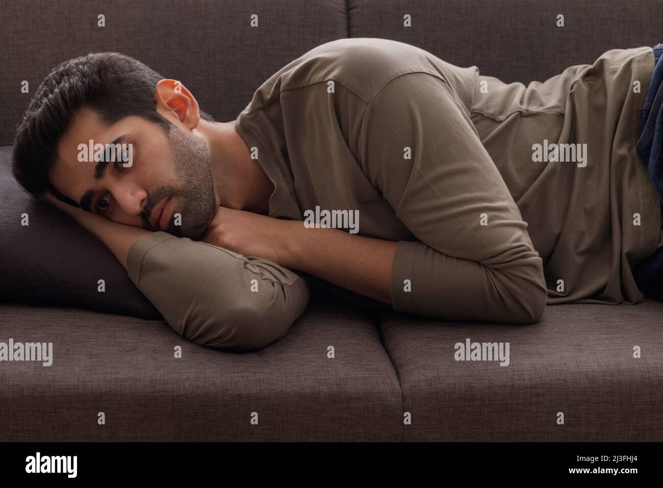Ritratto di un giovane sdraiato sul divano a casa Foto Stock