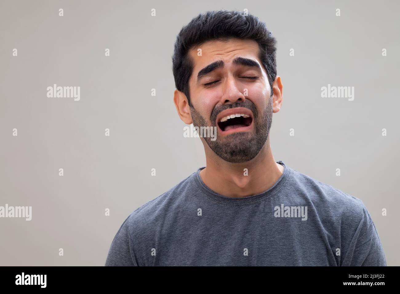 Ritratto di un giovane triste che piange con gli occhi chiusi Foto Stock