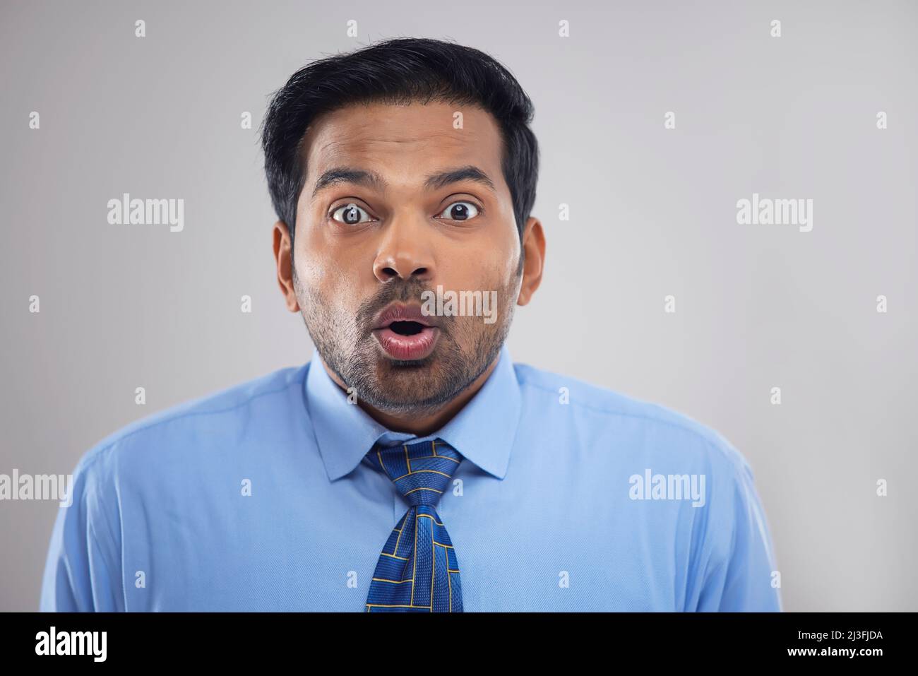Ritratto di un uomo d'affari sorpreso che guarda la fotocamera con occhi larghi Foto Stock
