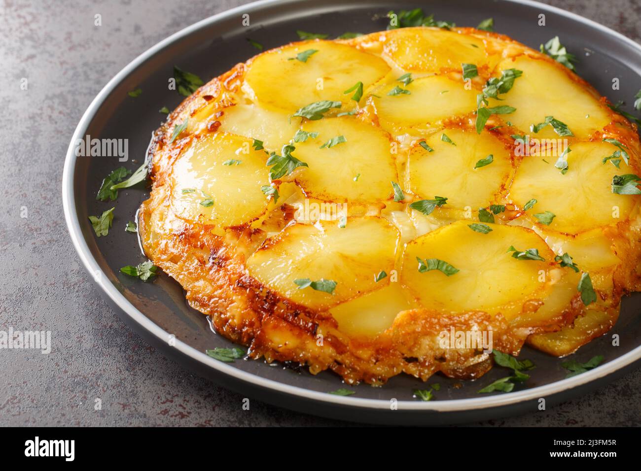 Le patate in padella Haggerty sono tagliate a fette, cipolle saltate, condite con il closeup di formaggio Dubliner nel piatto sul tavolo. Orizzontale Foto Stock