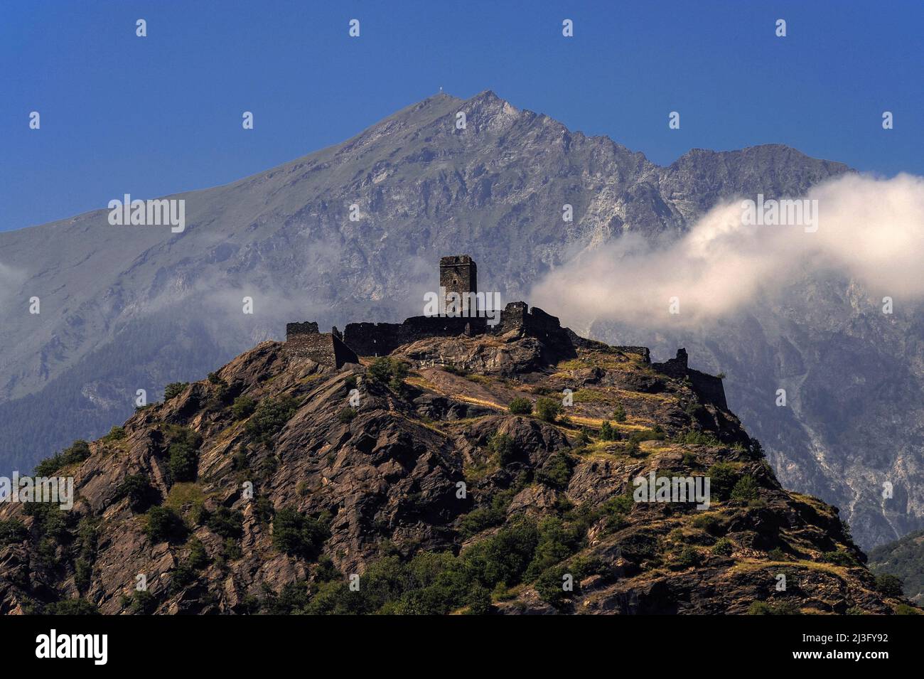 Sulla sommità di una falesia rocciosa, un castello medievale in rovina, il Castello di Saint-Germain, a Montjovet in Valle d'Aosta, Italia. Costruito tra l'XI e il XII secolo, la posizione strategica del castello in posizione elevata forniva sia un'eccellente difesa contro gli attacchi sia un punto di osservazione per monitorare il movimento delle persone e il commercio attraverso la valle sottostante. Foto Stock