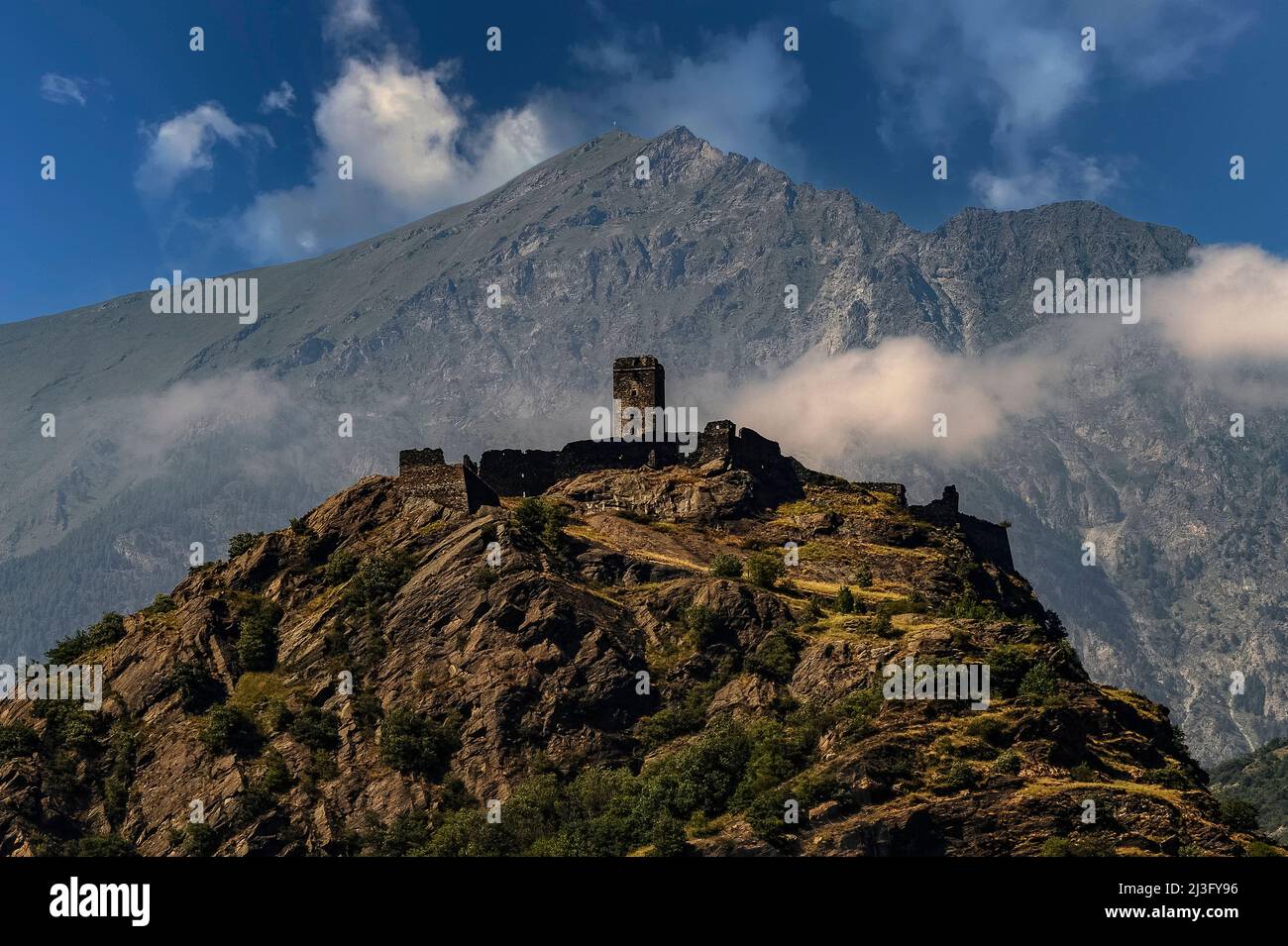 Il Castello di Saint-Germain, fortezza medievale tra vette alpine e un precipizio, a Montjovet, in Valle d'Aosta. Ora in rovina, il castello un tempo controllava il traffico utilizzando un'antica strada romana e un percorso di pellegrinaggio cristiano dalla Francia. Fu costruito dalla famiglia Montjovet o Mongioveto a 656 metri (2.152 piedi) sul livello del mare, su una falesia rocciosa che era stata occupata in epoca neolitica ed era conosciuta ai Romani come Mons Jovis. Foto Stock