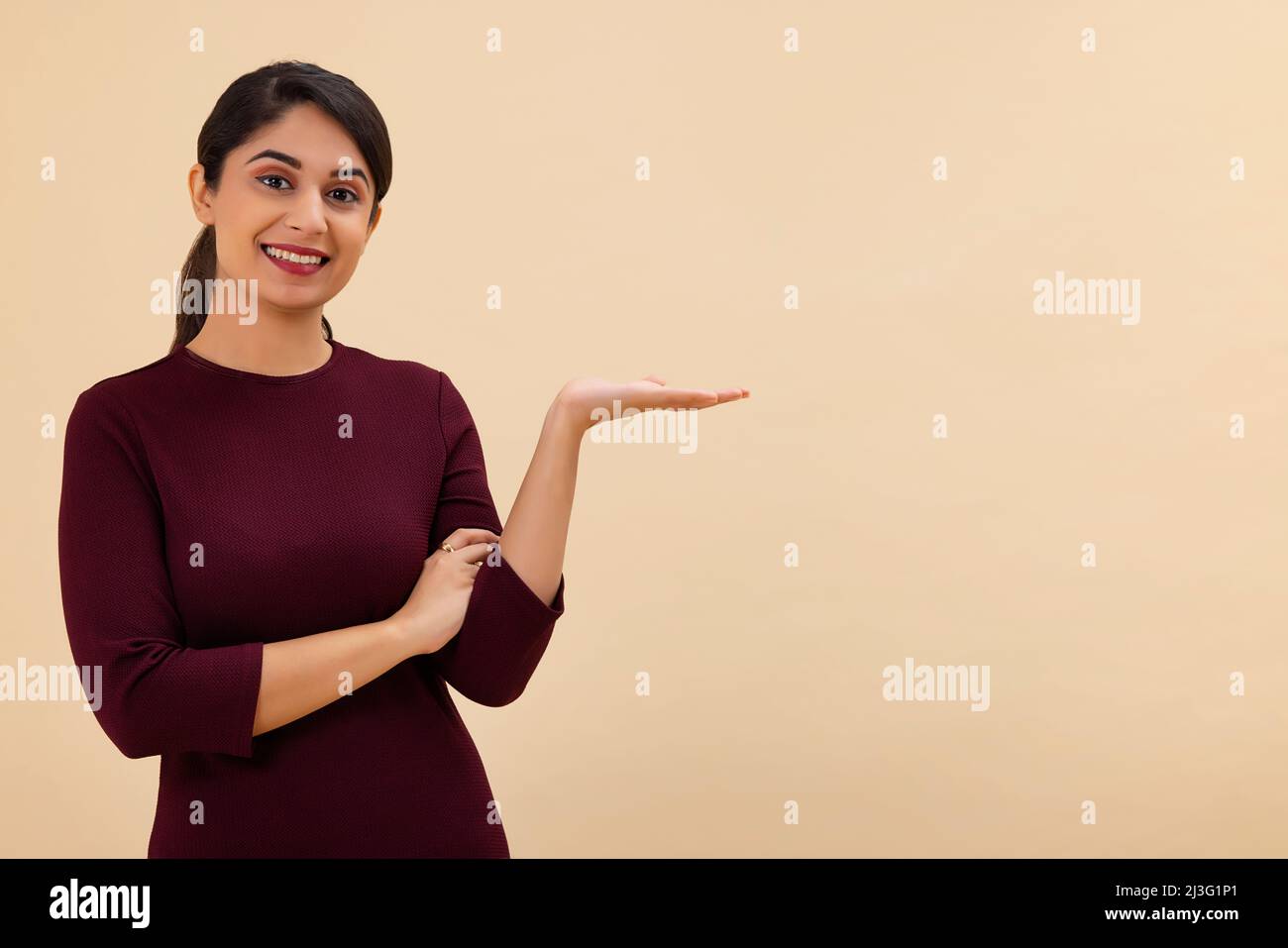 Ritratto di una giovane donna che guarda la macchina fotografica con la mano tenere il palmo in su Foto Stock