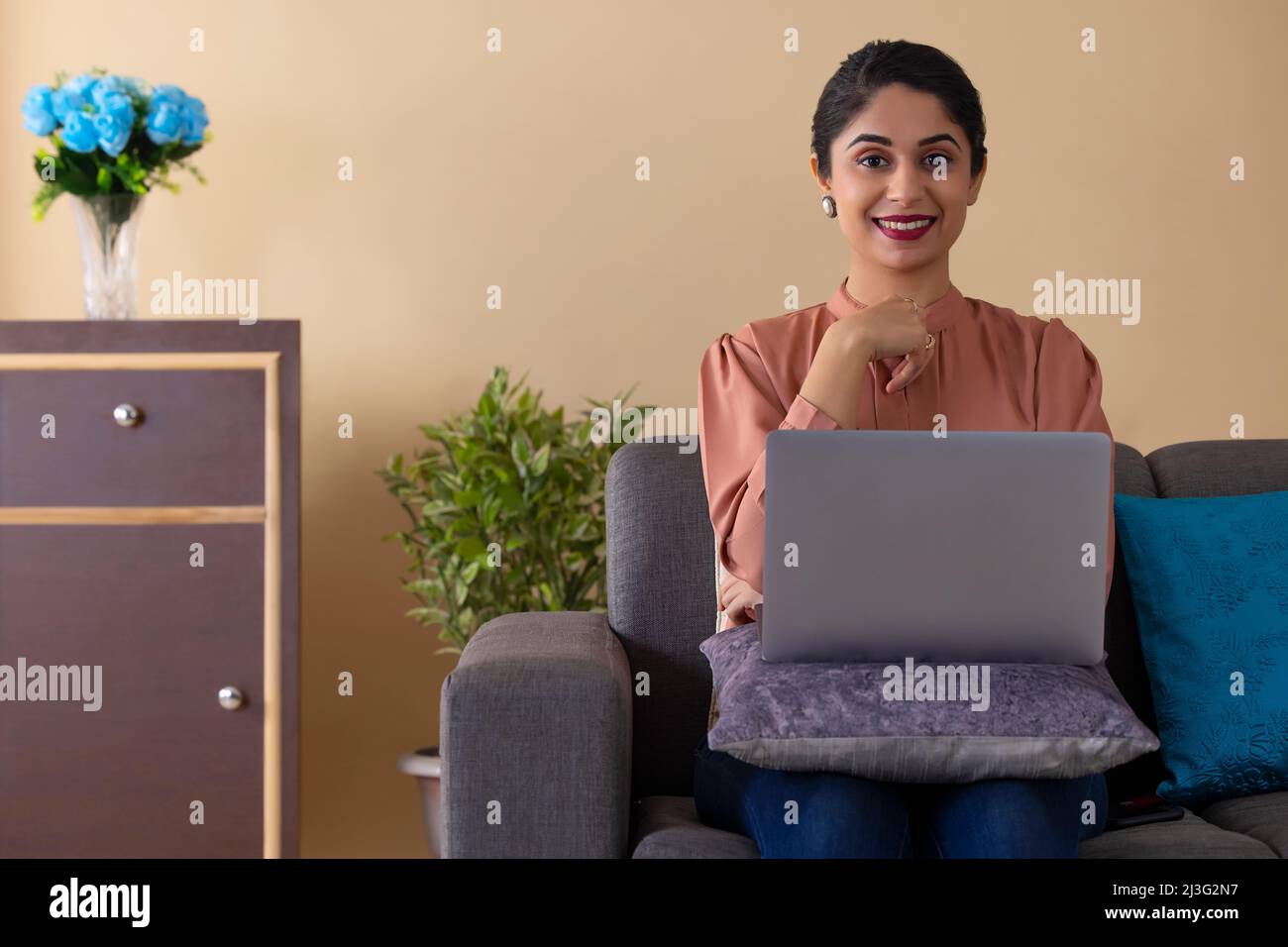 Felice donna indiana che lavora da casa utilizzando un laptop Foto Stock