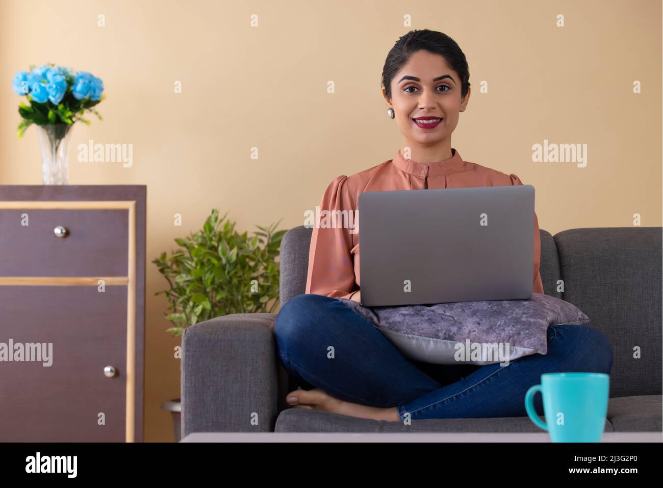 Felice donna indiana che lavora da casa utilizzando un laptop Foto Stock
